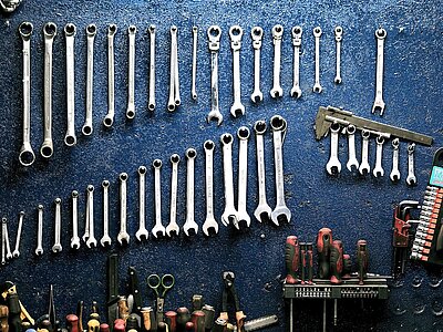 Ordentlich sortierte Werkzeugsammlung vor blauem Hintergrund