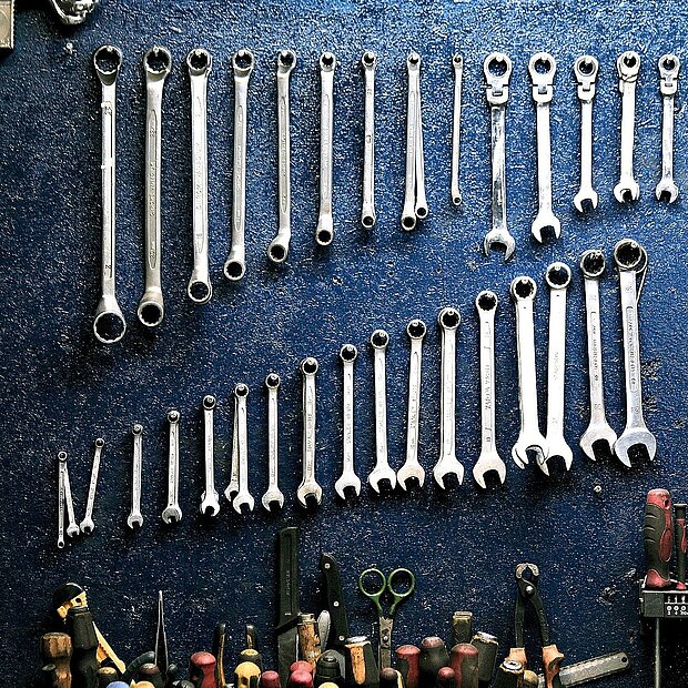 Ordentlich sortierte Werkzeugsammlung vor blauem Hintergrund