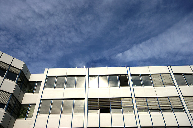 Ein weißes Gebäude im Vordergrund eines dunkelblauen Himmels in extremer Perspektive