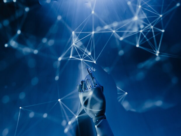Eine Roboterhand berührt einen Bildschirm mit weißen Linien, die Vernetzung darstellen