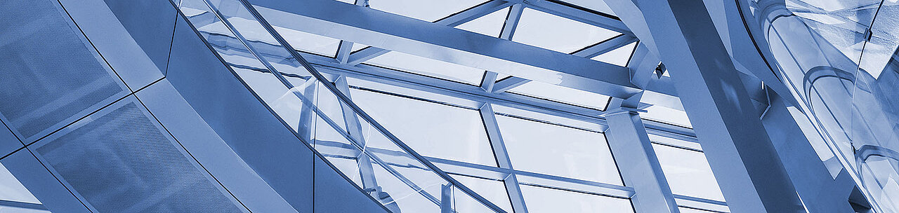 Innenansicht des Gebäudes mit Glasdach und grauen Treppen